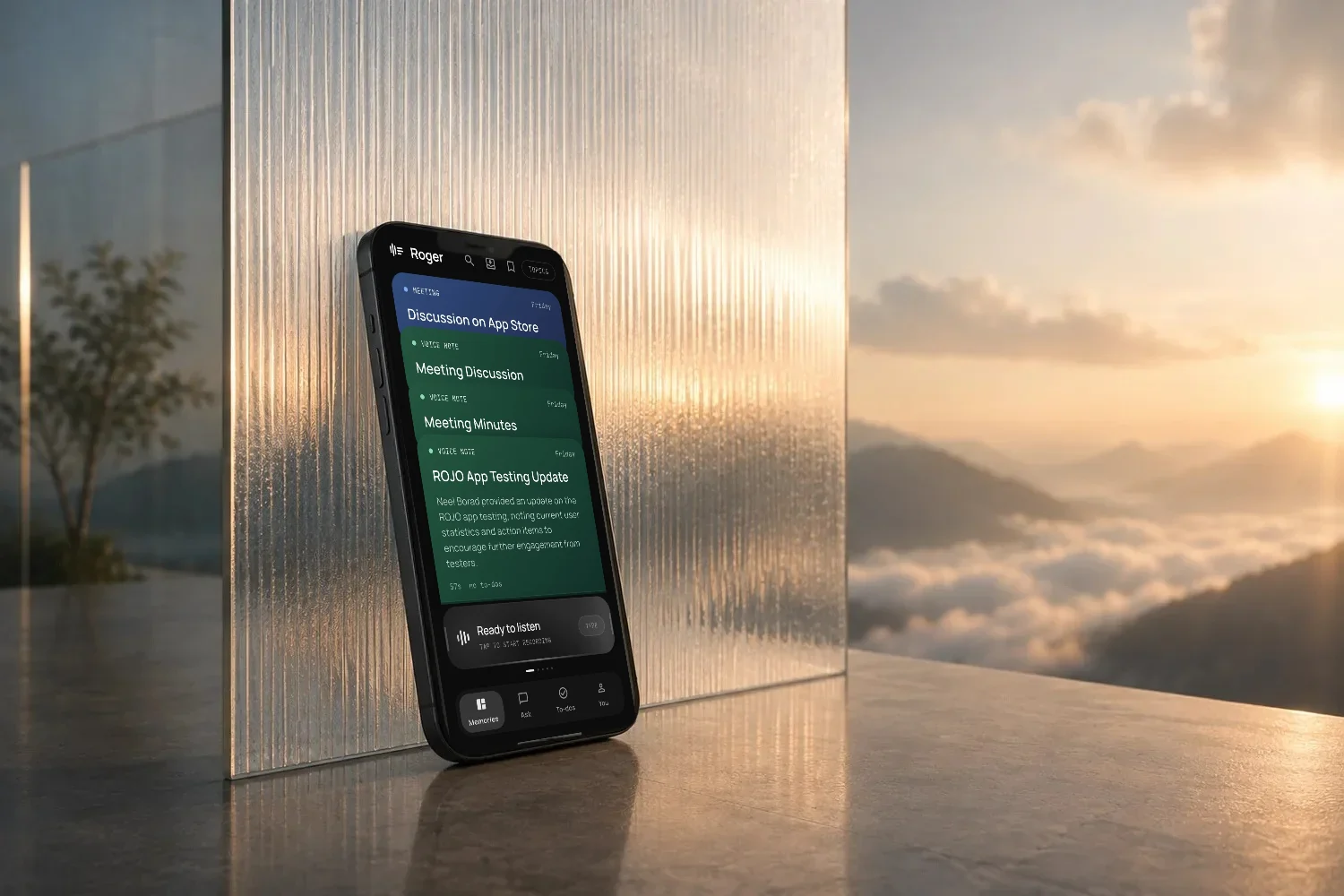 A phone leaning on ribbed glass at sunset, showing a feed of Roger memories from meetings and voice notes